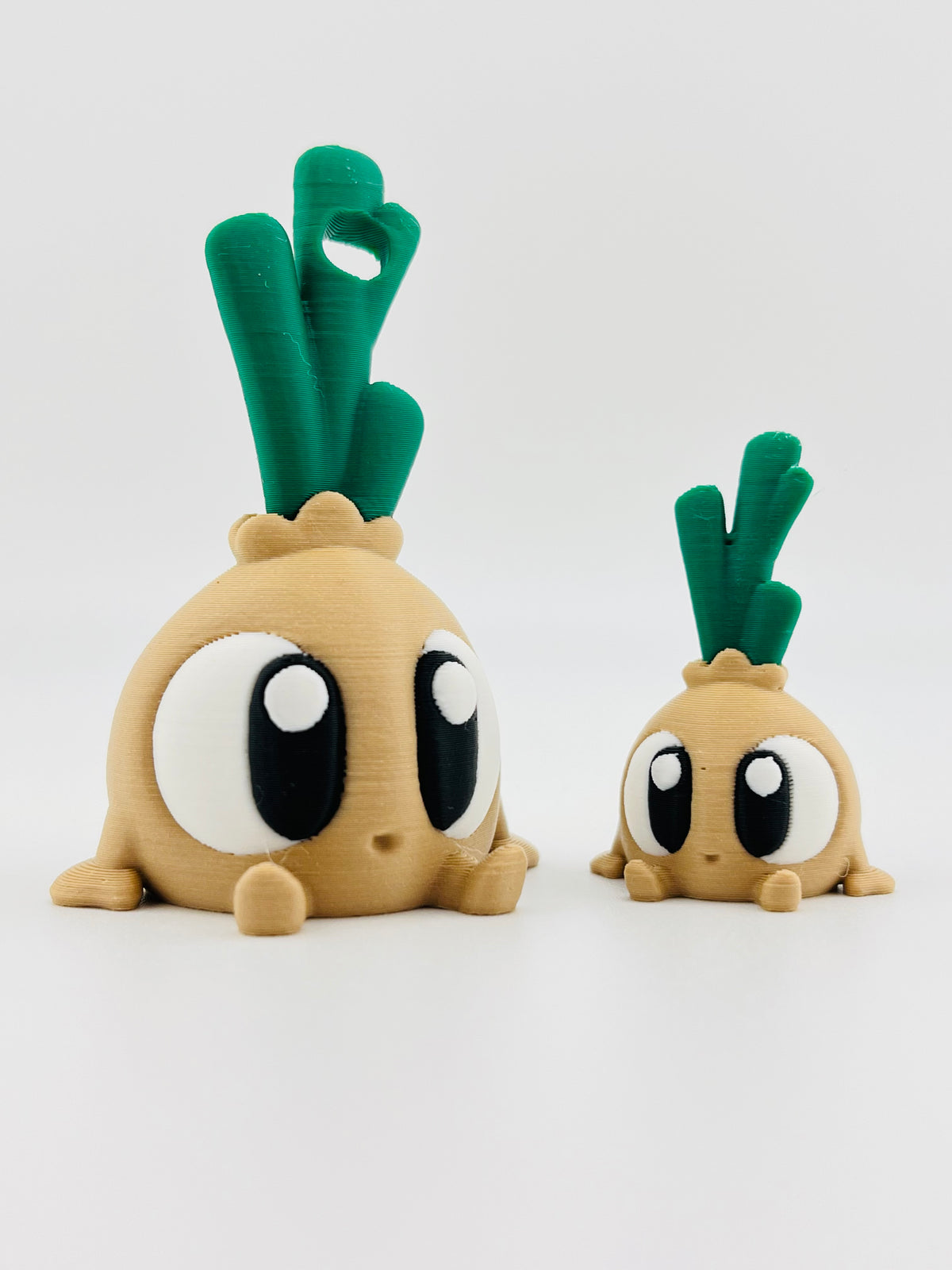 Onion fidget toys with green tops and big eyes, in large and small sizes