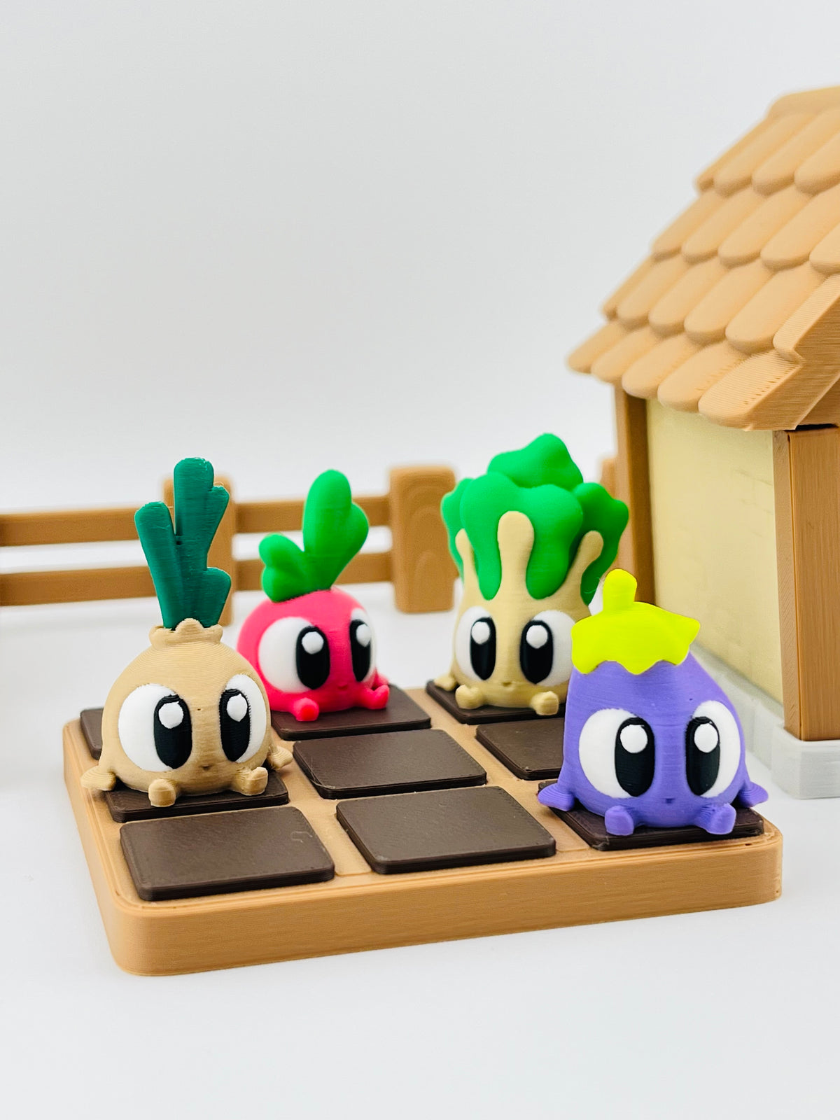 Onion, radish, pak choi and aubergine fidget toys in a wooden veg patch display with a little cottage