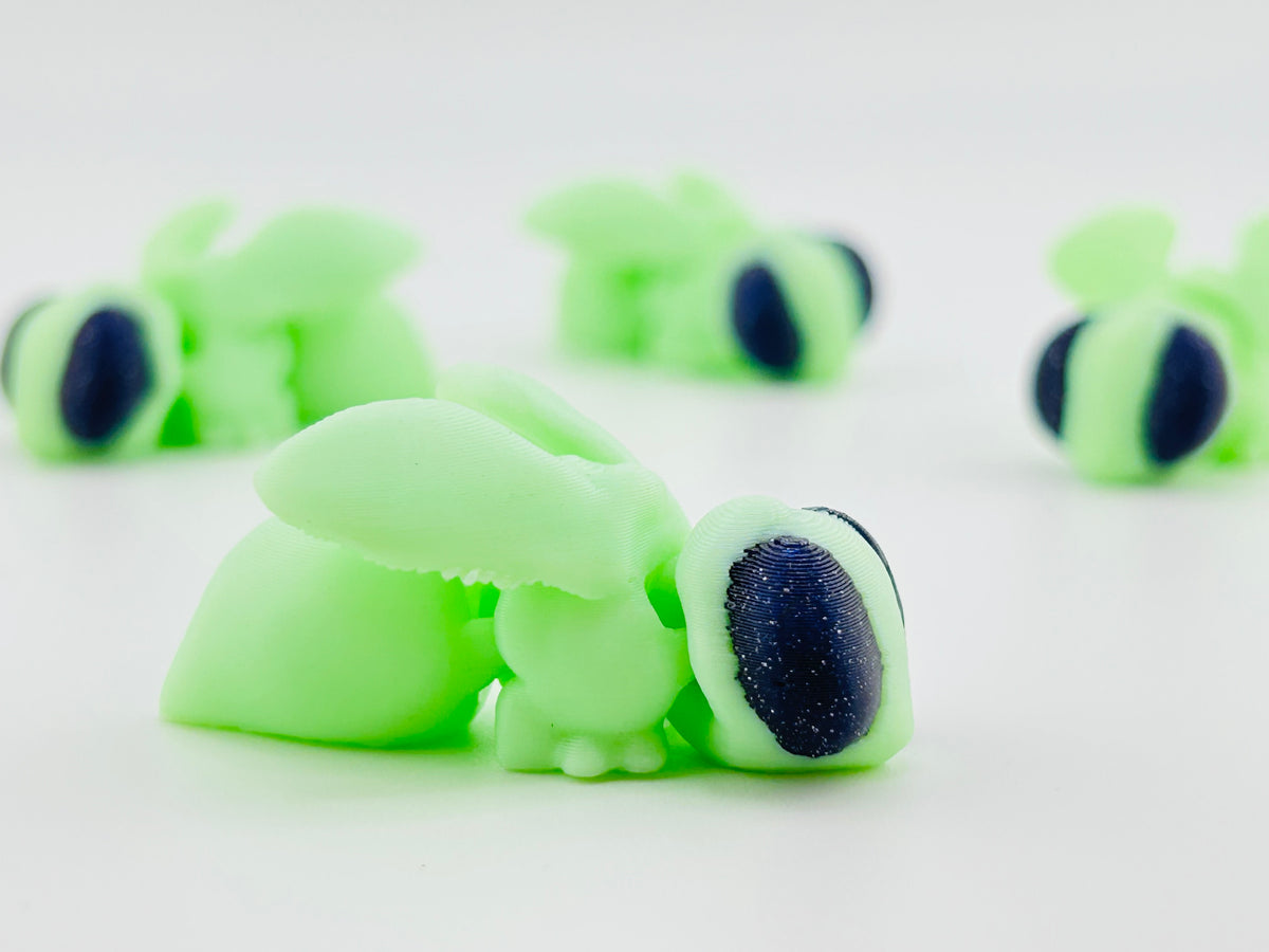 Glow-in-the-dark green glow fly fidget toys with large glittery navy eyes