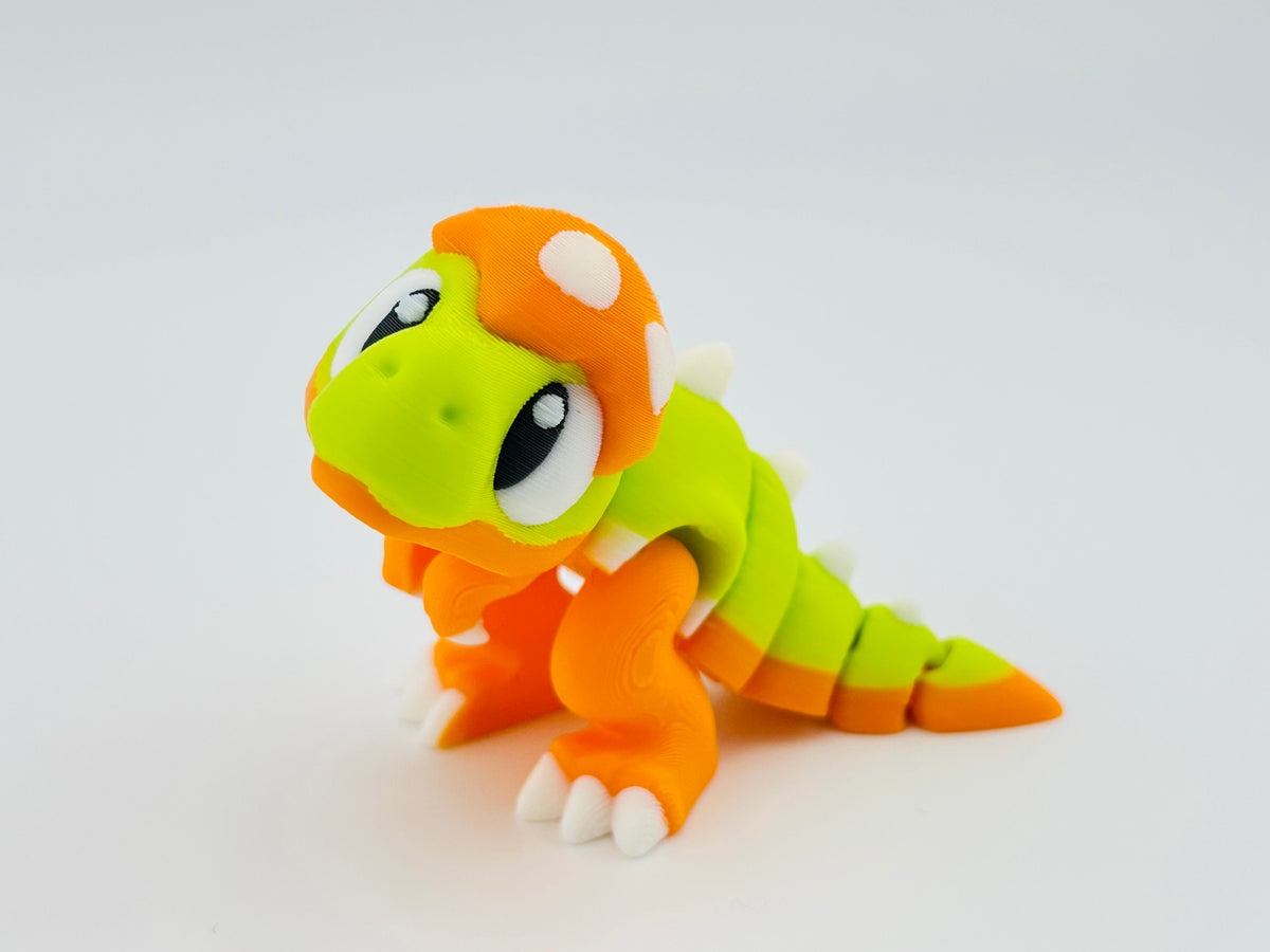 Orange and lime green baby dinosaur fidget toy with white spots
