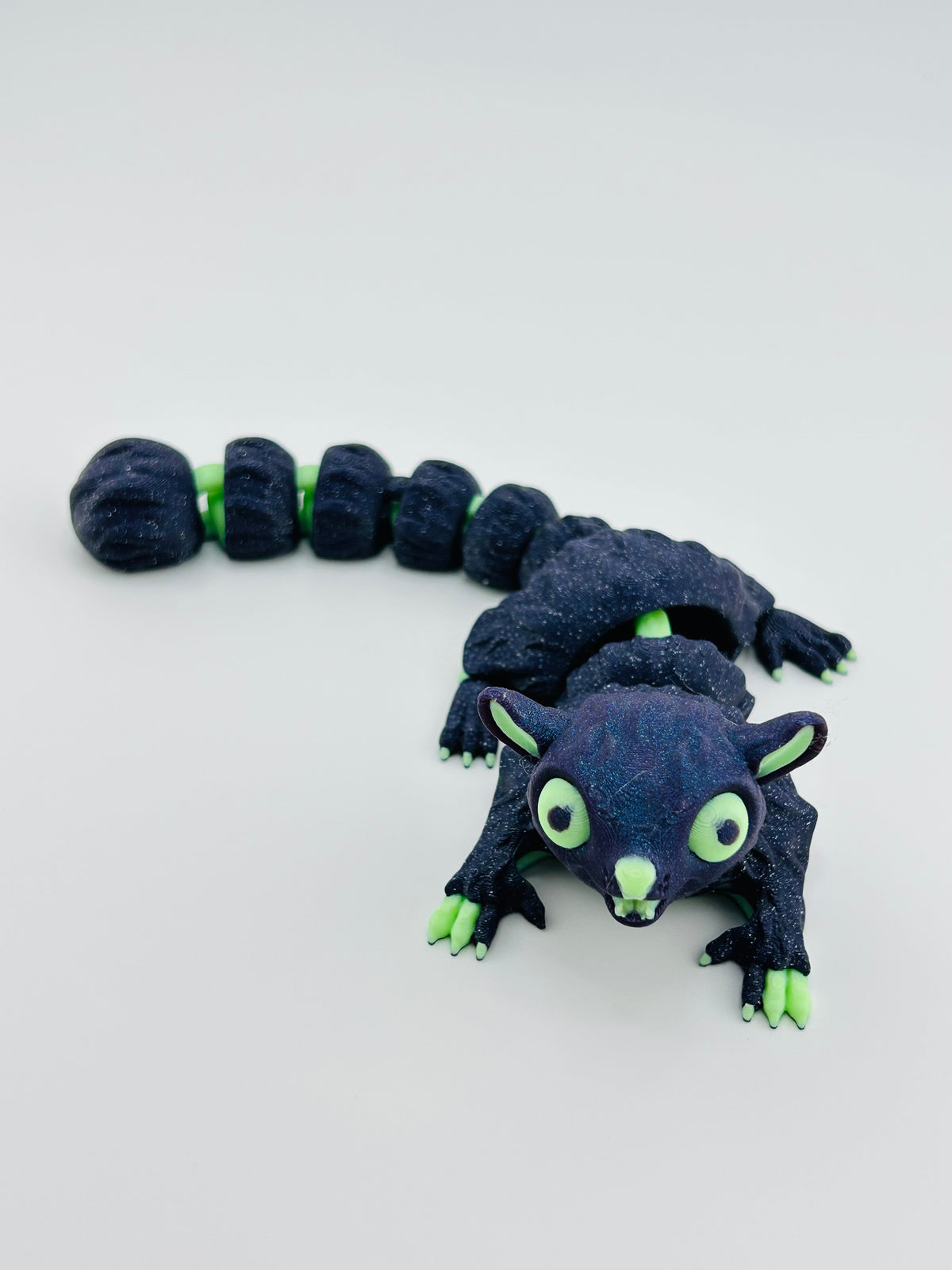 Navy glow sugar glider fidget toy with a long articulated tail and glow-in-the-dark green details